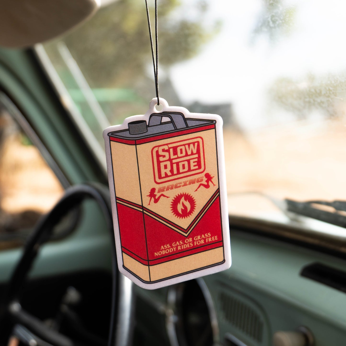 Gas Can Air Freshener - Slow Ride Retro-style Slow Ride Racing air freshener shaped like a vintage gas can, hanging in a classic Volkswagen bus. Perfect for fans of Off-Roading, Off-Road Racing, and vintage Volkswagen culture, including the Volkswagen bug and Baja bug. This unique accessory is ideal for anyone who embraces the Garage and Racing lifestyle, Slow Ride Garage, and the mottos 'Enjoy Getting There,' 'Wheelin and Spilling,' and 'Restore and Destroy.' A great addition to any vintage Volkswagen or b