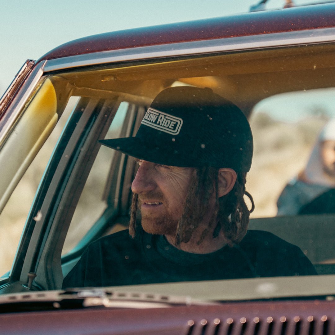 Radio Trucker Hat (Black) - Slow Ride- Black Slow Ride mesh trucker hat featuring bold logo, perfect for Volkswagen bus and vintage Volkswagen enthusiasts. Ideal for off-roading, off-road racing, and Baja bug fans. A staple accessory for the Garage and Racing lifestyle, whether you're enjoying getting there or engaging in wheelin' and spilling. This hat embodies the spirit of restore and destroy, making it a must-have for blue-collar workwear. Elevate your style with this durable, comfortable Slow Ride hat